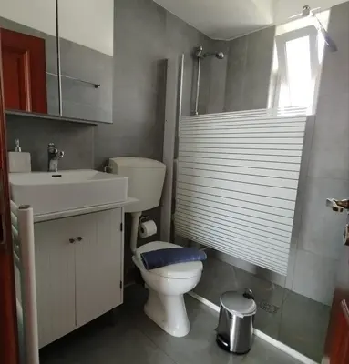 a bathroom with a toilet and a sink and a window at Stylish summer flat, close to beach in Daratso