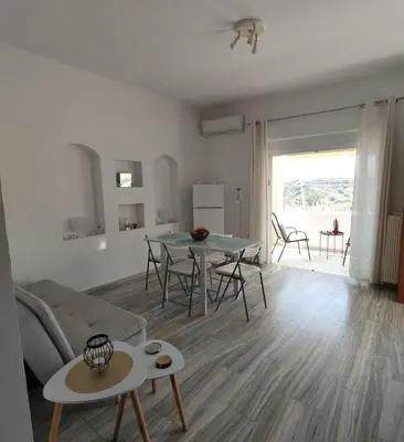 a living room with a table and a couch at Stylish summer flat, close to beach in Daratso