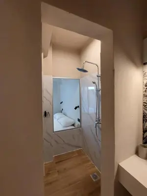 a bathroom with a shower with a mirror at Chavalon Apartments in Kalyves
