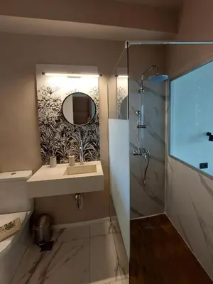 a bathroom with a sink and a mirror and a shower at Chavalon Apartments in Kalyves