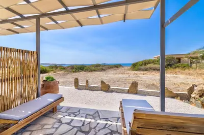 a patio with a bench and a view of the beach at A to Z in Palaiochóra