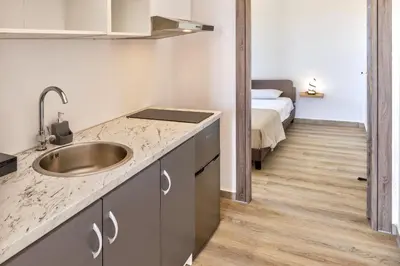 a kitchen with a sink and a bed in a room at A to Z in Palaiochóra