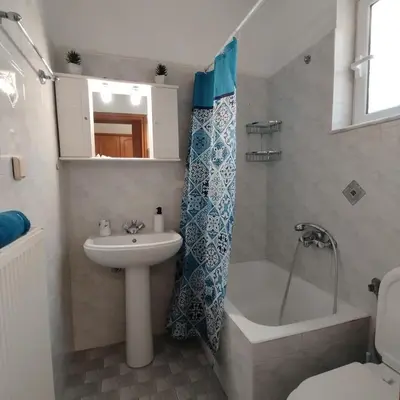 a bathroom with a sink and a tub and a toilet at Hillside Escape by the Sea in Daratso