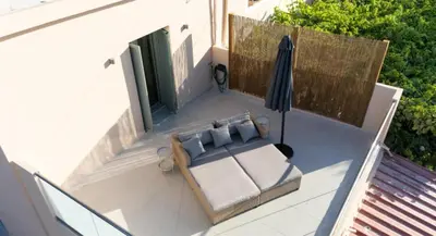 an umbrella and a couch on a patio at Roots Villa in Skinés