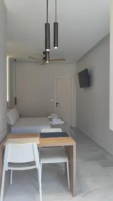 a dining room with a table and a bed at Dabia Escape in Chania Old Town in Chania Town