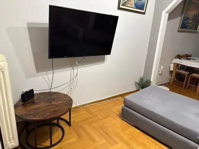 a living room with a table and a flat screen tv at Chania City Center Apartment with Balcony Central Aircon in Chania Town