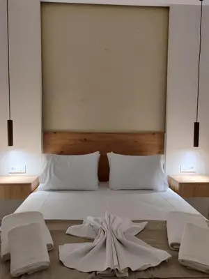 a bedroom with a bed with white sheets and pillows at Dimora Cozy Retreat in Chania Old Town in Chania Town