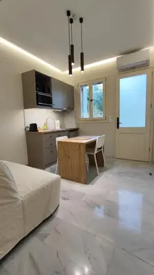a living room with a table and a kitchen at Dimora Cozy Retreat in Chania Old Town in Chania Town