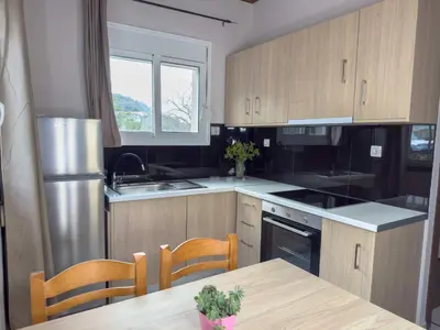 a kitchen with wooden cabinets and a table and a sink at Suites Near Elafonisi in Élos