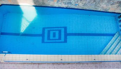 a swimming pool with blue tiles on the bottom at Popi Hotel Apartments in Agia Marina Nea Kydonias