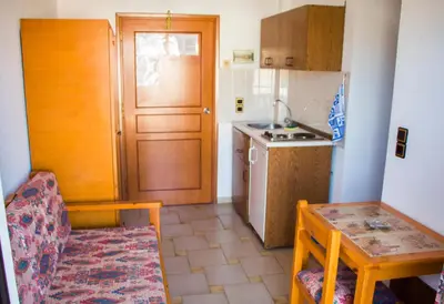 a small kitchen with a table and a table and a chair at Popi Hotel Apartments in Agia Marina Nea Kydonias