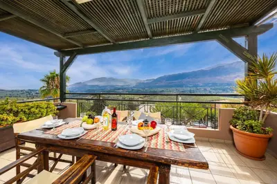 a table on a balcony with a view of the mountains at Aloni Villa in Káïna