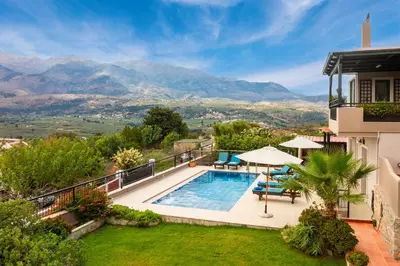 a villa with a swimming pool and mountains in the background at Aloni Villa in Káïna