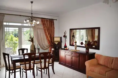a dining room and living room with a table and chairs at Villa Esperado Gardens Maleme in Maleme
