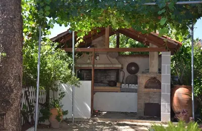 a outdoor kitchen with a pizza oven in a yard at Villa Esperado Gardens Maleme in Maleme
