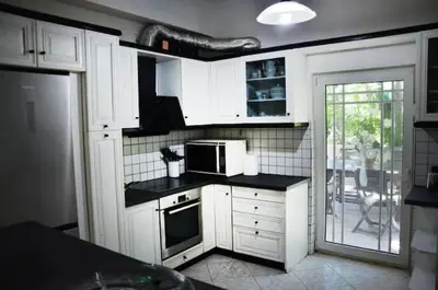 a kitchen with white cabinets and a microwave at Villa Esperado Gardens Maleme in Maleme