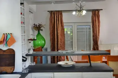 a kitchen with a table and a green vase at Villa Esperado Gardens Maleme in Maleme