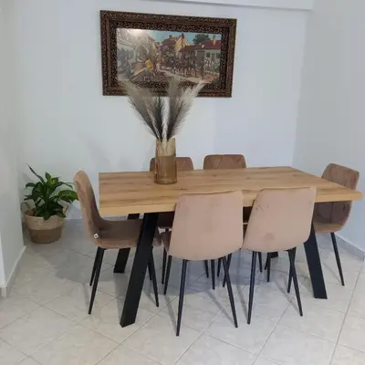 a dining room table with chairs and a picture on the wall at Kornaros House in Chania Town
