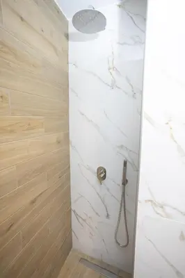 a bathroom with a shower with white marble at Chania Moments in Chania Town