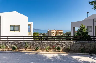 a house with a stone wall and a fence at Sense of Dream Villas in Tavronitis