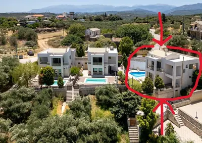 an aerial view of a large white house with a red arrow at Sense of Dream Villas in Tavronitis