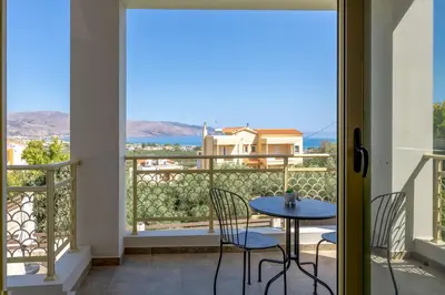 a balcony with a table and chairs and a view of the ocean at Sense of Dream Villas in Tavronitis