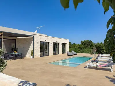 a swimming pool with lounge chairs next to a house at PanStel Twin Villas with private pools and jacuzzi in Ayiá
