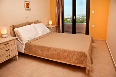 a bedroom with a bed and a window with a view at Villa Lofos in Perivólia