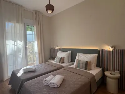 a bedroom with two beds with towels on them at Nature spacious apt, 2km from Chania old town, private parking in Chania Town