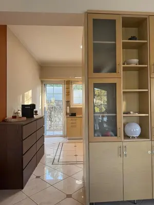 a kitchen with a large wooden cabinet and a counter at Nature spacious apt, 2km from Chania old town, private parking in Chania Town