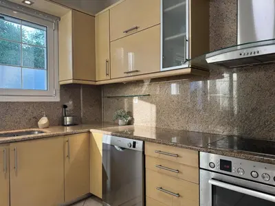 a kitchen with wooden cabinets and stainless steel appliances at Nature spacious apt, 2km from Chania old town, private parking in Chania Town