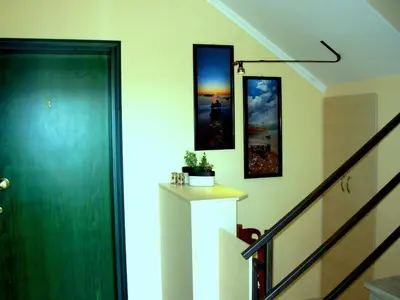 a hallway with a green door and pictures on the wall at Callista sea view or garden in Kissamos