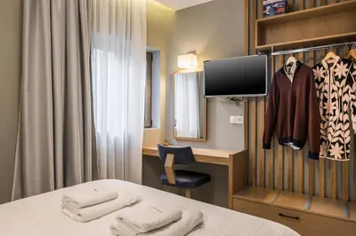 a room with a bed and a desk and a tv at Mirma City apartment2 Old Town in Chania Town