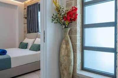 a vase with flowers in a room with a bed at Villa Grand Fysaeri in Vamos