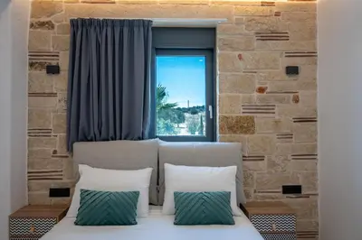 a bed with two pillows in a room with a window at Villa Grand Fysaeri in Vamos