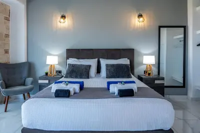 a bedroom with a large bed and a chair at Villa Grand Fysaeri in Vamos