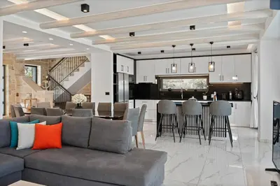a living room and kitchen with a couch and a table at Villa Grand Fysaeri in Vamos