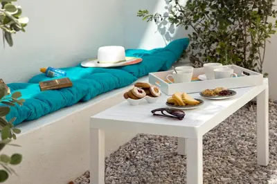 a white table with food on it next to a couch at S&K Villas in Kalamaki Chanion
