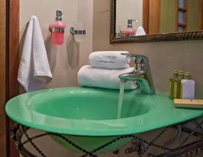 a bathroom with a green sink and a mirror at Ionas Boutique Hotel in Chania Town