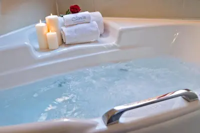 a bath tub with two candles and towels in it at Ionas Boutique Hotel in Chania Town