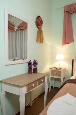 a bedroom with a table and a mirror and a bed at Casa Di Porto in Chania Town