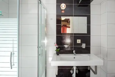 a white bathroom with a sink and a mirror at Casa Di Porto in Chania Town