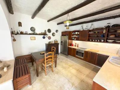 a kitchen with a table and chairs in a room at Elafonisi Manor with Private Pool & Jaccuzi in Perivólia