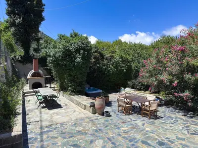 a patio with a table and chairs and a fireplace at Elafonisi Manor with Private Pool & Jaccuzi in Perivólia