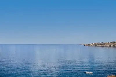 a boat in the middle of a large body of water at Casa Domenica, 2 bedroom seaside home in Chania Town