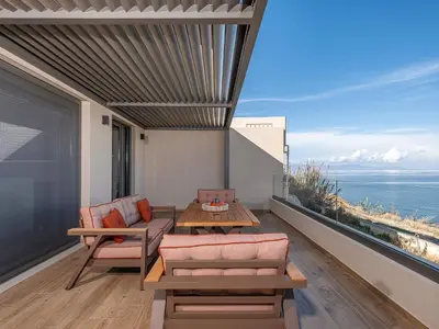 a balcony with a table and chairs and a view of the ocean at Casa Domenica, 2 bedroom seaside home in Chania Town