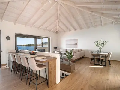 a kitchen and living room with a table and chairs at Casa Domenica, 2 bedroom seaside home in Chania Town