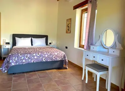 a bedroom with a bed and a dressing table and a mirror at Wild Tulip Escape in Kolymvari