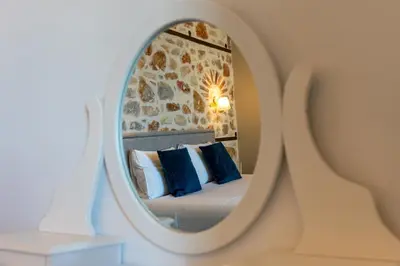 a bedroom with a bed and a mirror at Villa Enid in Sinoikismós Mamounianá