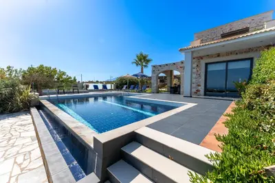 a swimming pool in a backyard with a house at Villa Enid in Sinoikismós Mamounianá